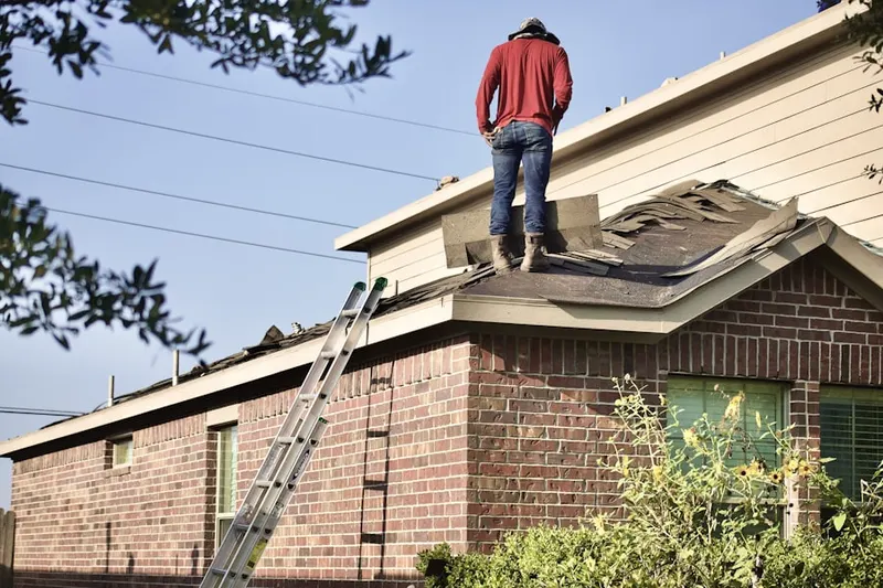 Professional roofer working on a residential roof in Holmes Foster